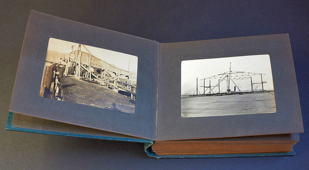 Photograph album open to display two black and white photographs, one on each page.
