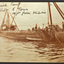 Two work boats bow to bow at the end of a small wharf. One of the boats has a block and tackle and several men spread between the two boats and the wharf are working to lift some timber from the water.