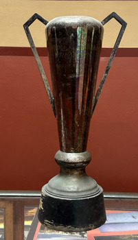 Large cup on a wooden base with angled handles