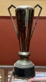 Large cup on a wooden base with angled handles
