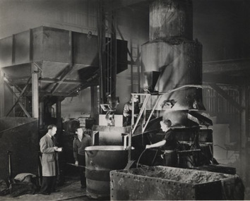 Black & white photo of three men working at their job.