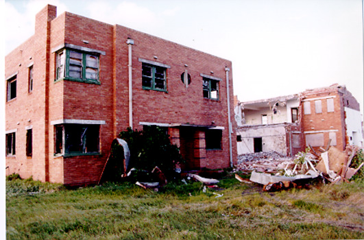 Coloured photo of two buildings be pulled down.