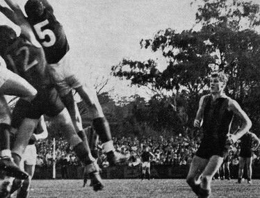 2268 - Gary Brice playing football, watching players contest a mark, 1967