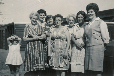 Seven ladies and a young girl standing for a photograph.