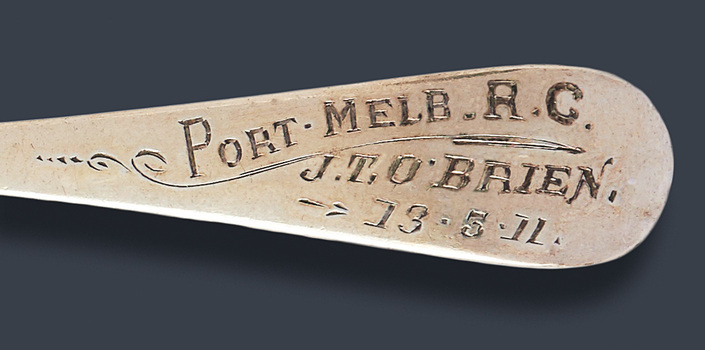 Close-up view of the engraving on the handle of the teaspoon.