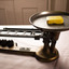 A set of manual scales with a bar of yellow soap sitting on the pan.