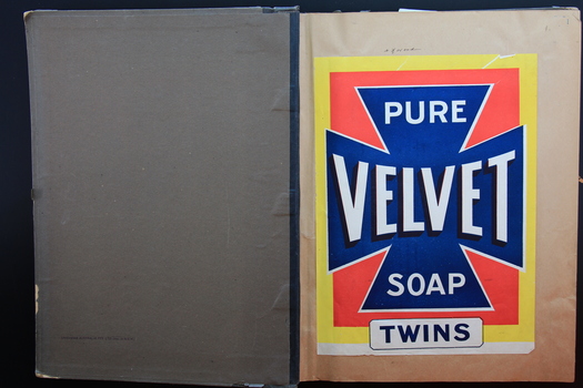 A large book showing a Velvet soap label pasted on to one of the pages.