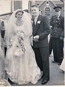 Weeding couple posing before they enter the bridal car.