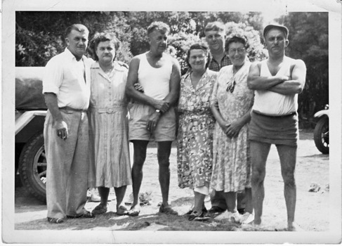 A group of men and women standing, posing for the camera.