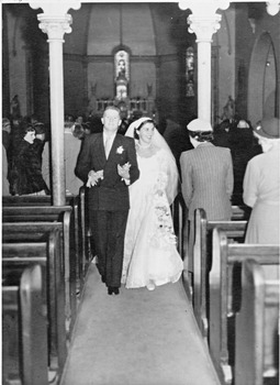 Bride and groom walking down the aisle of a church.
