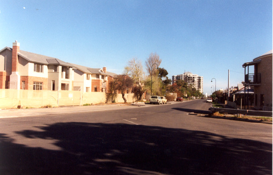  Brick and wooden two story houses under construction,  in the background a high rise appartments can be seen.                                  
