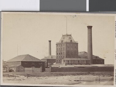 A side view of the Sugar Works in  Sandridge, 1870, also showing two very large chimneys which are connected to two of the buildings.
