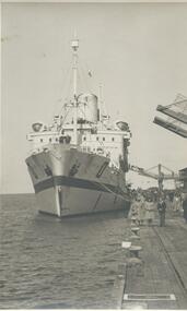 Photo shows the  "Oranje" bow when she was berthed at Princes Pier. You can also see the gangways connected to the arrival building and a. group of people having their photos taken in front of the ship. 