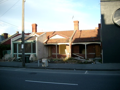 Three small partially demolished brick cottages