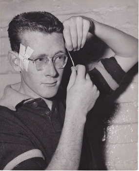 2905.01 - Dan Manson preparing for a football match, taping his glasses to his head
