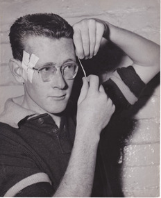 2905.01 - Dan Manson preparing for a football match, taping his glasses to his head