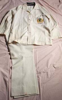 White jacket with insignia on the breast pocket and white trousers.