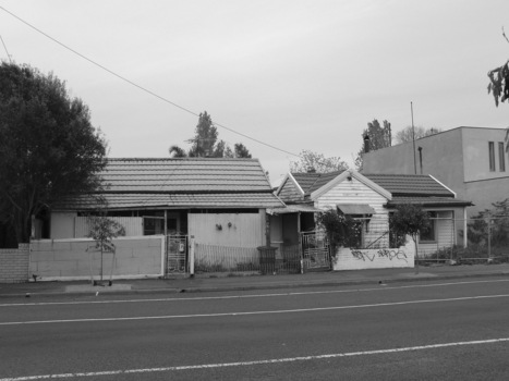 Black and white photograph of a somewhat rundown house.