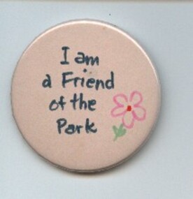 A white round badge with a pick flower and the words 'I am a Friend of the Park'.