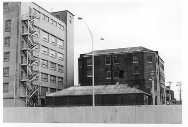 Two buildings - one multi-storey with external stairs and an older four or five storey brick building.