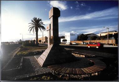 View of an abstract sculpture in the foreground looking along the foreshore.
