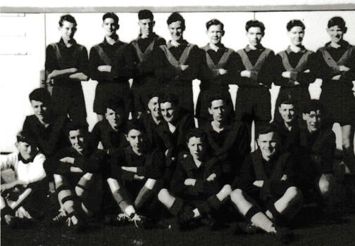 Group of men posing in three rows in typical football team formation.