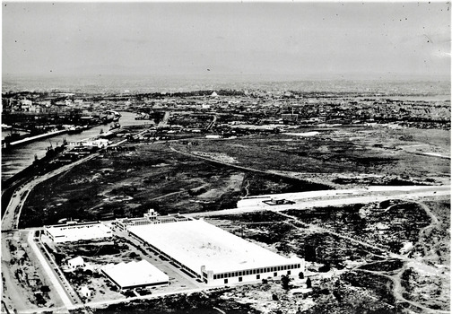 Black and white aerial photograph looking over an industrial area.