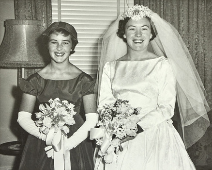 A bridesmaid and bride posing for the camera.