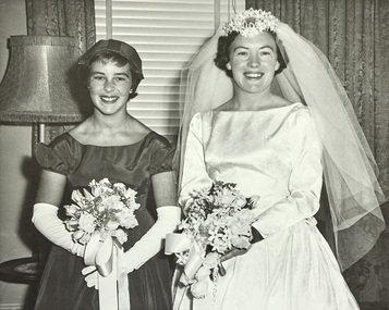 A bridesmaid and bride posing for the camera.