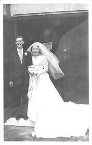 A bride and groom standing in a doorway