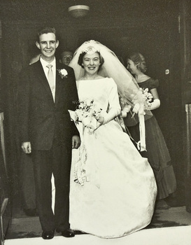 A groom and bride posing in a doorway