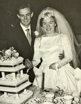 Bride and groom cutting a multi-tier wedding cake