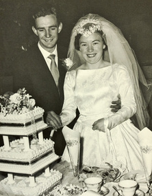 Bride and groom cutting a multi-tier wedding cake