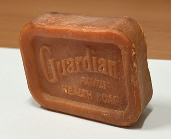 Orange-coloured bar of soap embossed "GUARDIAN FAMILY HEALTH SOAP"