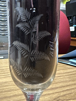 A decorative fern engraved on the bowl of a drinking glass