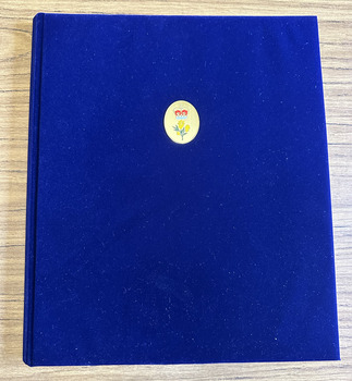 Blue folder with an small oval insert bearing a crown and wattle.