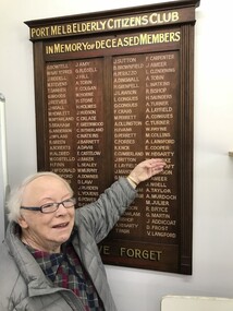 Photograph - Barbara Gardiner pointing to her father's name on the Port Melbourne Elderly Citizen Club board, c.2010