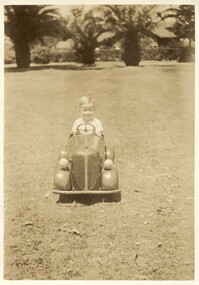 Photograph - Fred Nicholson in toy car at Edwards Park, 1940s