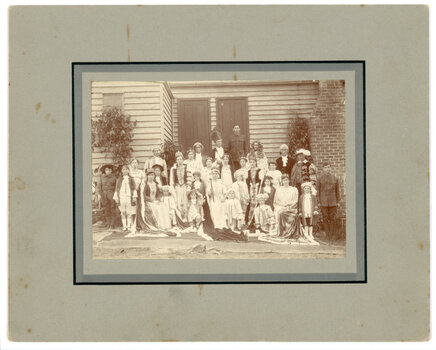A large group of children and adults in costumes dressed up for the Queen of Peace competition