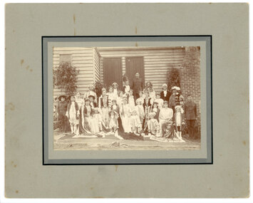 A large group of children and adults in costumes dressed up for the Queen of Peace competition