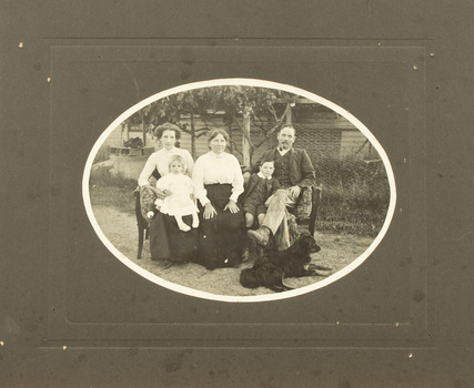 Black and white photograph mounted on cardboard of family group