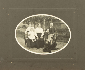 Black and white photograph mounted on cardboard of family group