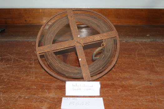 Steel measuring band rolled onto a spool rusty