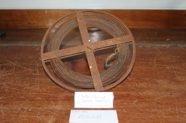 Steel measuring band rolled onto a spool rusty
