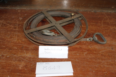 Rusted steel measuring band rolled onto a spool