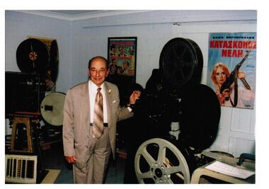 A man standing beside a film projector.