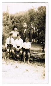 A family photograph of parents and three young boys.