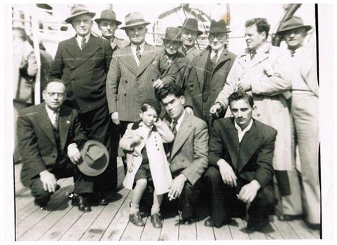 Eleven men and a boy on the deck of a ship.