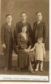 A family photograph with the parents, two young men and a little girl.