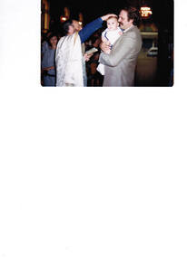 A Greek priest baptising a baby in a church.